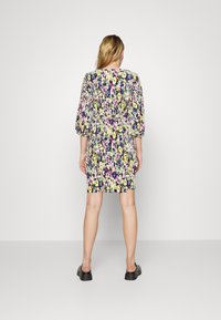 Vestido floral com mangas curtas e bufantes, cintura ajustada e comprimento até ao joelho. Apresenta um fundo escuro com flores vibrantes em amarelo, rosa e roxo.