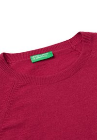 Bordowy sweterek dzianinowy z okrągłym dekoltem, z teksturowanym wzorem i zieloną metką z napisem "United Colors of Benetton."