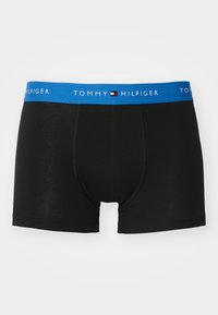 Boxer shorts en coton noir avec une ceinture élastique bleue arborant le logo "TOMMY HILFIGER". Texture lisse, design ajusté et longueur mi-cuisse.