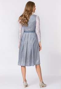 Hellblaues Kleid mit langen Spitzenärmeln, einem taillierten Oberteil und einem plissierten Rock. Verfügt über einen passenden Gürtel und ein florales Muster auf dem Stoff.