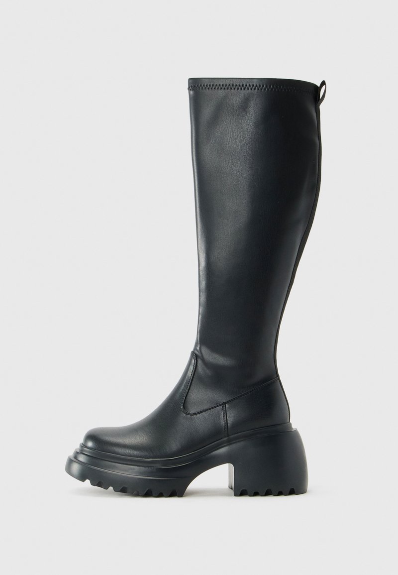 Tall black leather boot with chunky platform sole and block heel, featuring pull tab and textured tread on outsole.