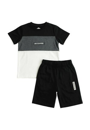 Chemise à manches courtes Lee Cooper noire, grise et blanche avec un short à taille élastique noire, les deux avec des écussons portant le logo Lee Cooper.