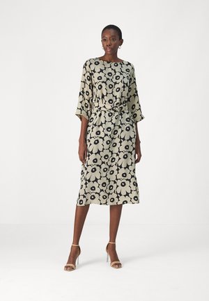 Floral patterned midi dress with beige background and black flowers, short sleeves, belted waist, and a relaxed fit.