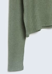 Haut en tricot côtelé vert à manches longues. Présente une coupe décontractée et une texture douce. L'ourlet a un bord légèrement incurvé.