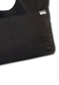 Sac en tissu noir avec une texture lisse, doté d'une poche latérale et d'une petite étiquette grise portant la mention "Bench". Design simple et fonctionnel.