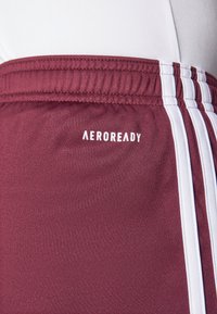 Bordeaux atletische shorts met witte streepdetails. Bevat het "AEROREADY" logo in het wit en een elastische tailleband van gladde, textuurstof.