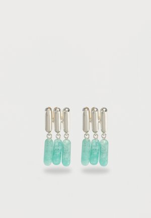 Sidabriniai auskarai su trimis vertikaliomis akva mėlynomis cilindrinėmis karoliukais, kabančiais nuo susietos sidabrinės juostos struktūros.