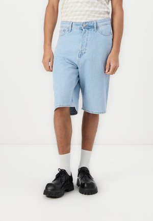 Light blue denim shorts with a straight cut, featuring a button closure and classic five-pocket design, worn with black shoes and white socks.