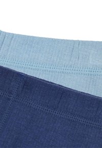 Dos pares de leggings de algodón: uno azul claro y otro marino. Ambos tienen cinturillas elásticas con un delicado detalle de costura. Tejido suave y texturizado.