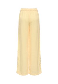 Pantalon large jaune clair avec une taille élastique, montré de dos sur fond blanc.