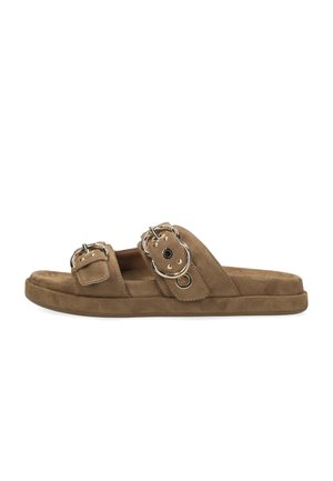 Sandalias planas de ante marrón con dos tiras anchas con herrajes circulares plateados y hebillas laterales. Suela plana con ligera amortiguación.