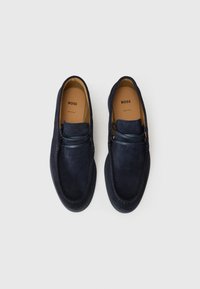 Loaferi din suede bleumarin cu vârful rotund, detalii de cusătură și o talpă din cauciuc moderna. Oferă un accent decorativ cu dantelă peste partea superioară.