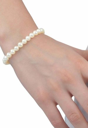 Bracciale di perle con perle bianche rotonde e lucide infilate elasticamente, indossato su una mano di tono della pelle chiaro, che mostra una texture liscia.