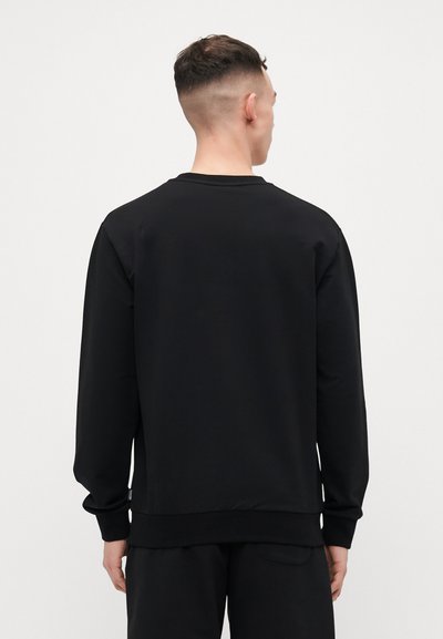 Black sweatshirt with long sleeves, crew neckline, ribbed cuffs and hem, made from a smooth fabric, featuring a minimalistic design with no visible logos.