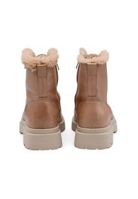 Braune Leder-Stiefeletten mit einem plüschigen beigen Kragen, einem seitlichen Reißverschluss und einer klobigen beigen Sohle, die eine strukturierte Oberfläche aufweist.