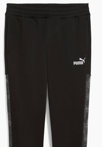 Pantaloni sportivi negri cu talie elastică, având un logo Puma alb și panouri laterale texturate de culoare gri. Material moale, design slim fit.