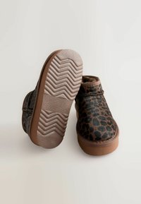 Læderstøvler med leopardmønster lavet af tekstureret stof, med rund tå og gummisulder med zigzag mønster for bedre trækkraft. Brune detaljer overalt.