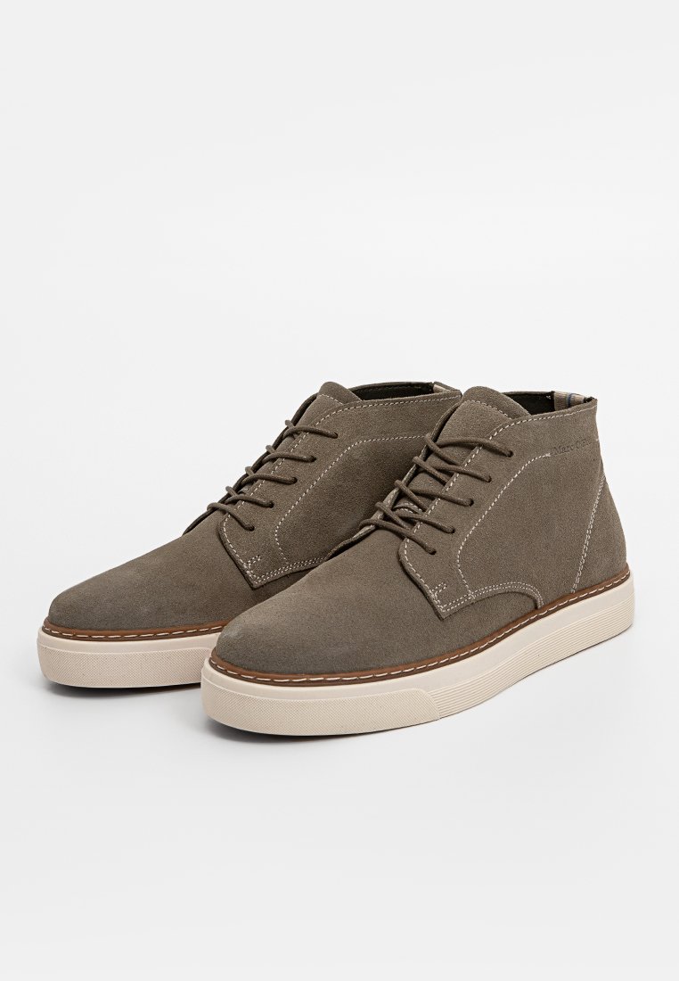 Braune Wildleder-Chukka-Schuhe mit runder Zehenpartie, vorderer Schnürung, kontrastierender Naht und beiger Gummisohle. Minimalistisches Design mit gepolstertem Kragen.