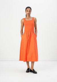 Orange sleeveless dress with a square neckline and gathered waist, featuring side pockets. Smooth fabric and A-line silhouette.