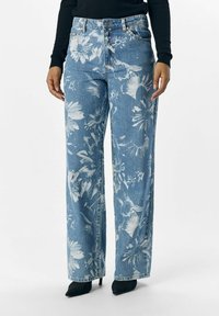 Jeans de pierna ancha de mezclilla con un estampado floral azul, con un lavado claro, cintura alta y un diseño de cinco bolsillos.