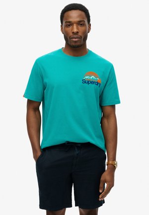Turquoise katoenen t-shirt met een geborduurde berg en het "Superdry" logo in het blauw, met korte mouwen en een ronde hals.