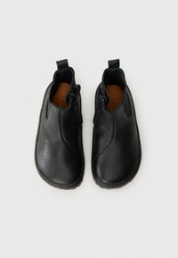 Black leather shoes with a textured finish, featuring side zippers, a rounded toe, and pull tabs at the rear for easy wear.