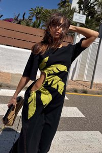 Zwarte oversized jurk met korte mouwen, met grote groene bladvormen en zijknipsels. Textuurstof met een ontspannen pasvorm ontwerp.