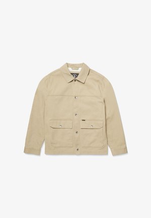 Veste beige à manches longues en coton avec un col, fermeture devant à boutons-pression et deux poches poitrine. Texture lisse.