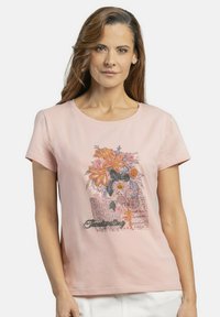 Camiseta de algodón rosa con mangas cortas, con bordado floral en naranja y púrpura, y el texto "Spellings Temáticos" en verde.