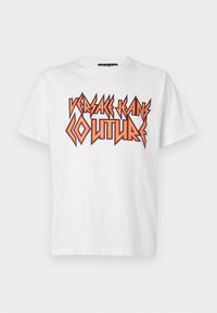 Tricou alb din bumbac cu un text grafic îndrăzneț, negru și portocaliu: "VERSACE JEANS COUTURE." Design cu mâneci scurte și guler rotund.