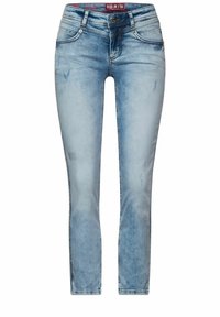 Svetle modré džíny s úzkým střihem, s vybledlým vzorem, pěti kapsami, zipovým zapínáním a lehkým opotřebením na stehnech.