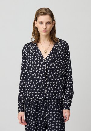 Completo pigiama navy con motivo floreale bianco, dotato di camicia con bottone, colletto e bordi a contrasto in pipetta. Tessuto morbido, maniche lunghe.
