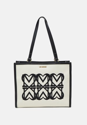 Musta-valkoinen kassi sydänkuviolla, valmistettu kankaasta, jossa on mustat nahkaosuudet ja -olkahihnat. Kulta "LOVE MOSCHINO" -logo edessä.