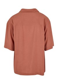 Camicia a maniche corte con colletto in tessuto terracotta, caratterizzata da una texture liscia e una vestibilità comoda. Presenta un yoke sul retro.