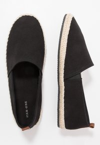 Black canvas espadrilles with woven jute soles and a slip-on design, featuring a round toe and minimal branding.