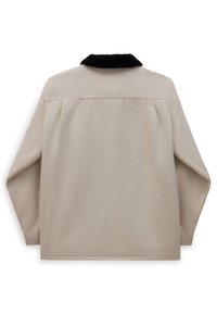 Beige Jacke mit einem schwarzen, strukturierten Kragen; lockere Passform und abgesenkte Schultern; glatter Stoff mit sichtbaren Nähten am Saum.