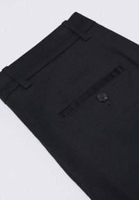 Black formal pants folded showing back pocket with button and belt loops on plain light background.