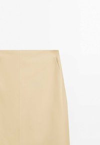 Jupe droite beige avec couture verticale et détail de poche latérale sur fond blanc uni.