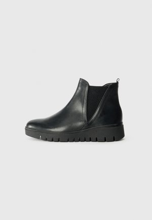 Botas de tobillo de cuero negro con paneles laterales elásticos, punta redondeada, suela de goma texturizada y una tira en la parte trasera.
