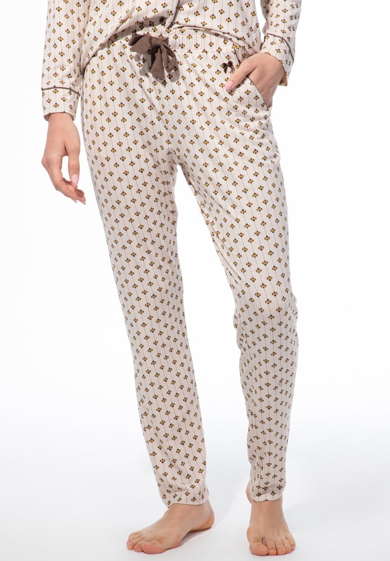 Leichte, gemusterte Schlafanzughosen in Creme mit braunen Blumen, ausgestattet mit einem elastischen Bund und einer dekorativen Schleife. Glatte Textur.