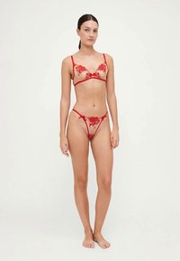 Rød blonde undertøysett med blomstermønster, gjennomsiktige kopper, justerbare stropper og matchende truse med minimal dekning.