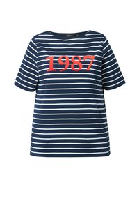 Camiseta de manga corta azul marino con rayas horizontales blancas y una gran impresión roja de "1987" en el frente. Fabricada en tela de algodón.