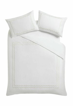 Weißes Bett mit zwei passenden Kissen, alle mit einem wellenförmig bestickten Rand.