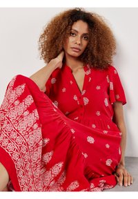 Rotes Blumenkleid mit kurzen Ärmeln, Knopfleiste und gerafftem Rock. Mit weißen Blumenmustern und einem strukturierten Saumdetail.