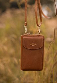 Brązowy skórzany portfel na ramię z zamkiem błyskawicznym, z przednią kieszonką, złotymi akcentami oraz odczepianym paskiem.