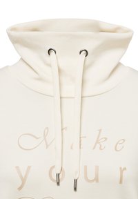 Cream-colored hooded sweatshirt with a tall collar, white drawstrings, and light beige text that reads "Make your". Soft texture.