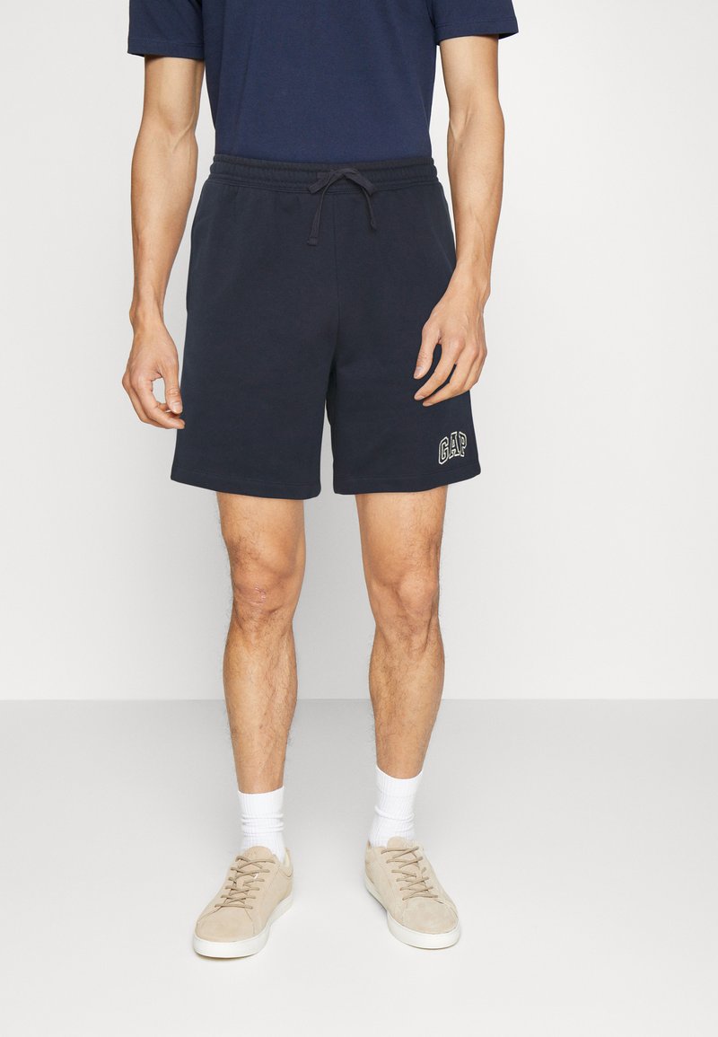 Marineblaue Baumwollshorts mit einem elastischen Bund und Kordelzug, mit einem in hellem Stickerei auf dem linken Oberschenkel aufgestickten GAP-Logo.