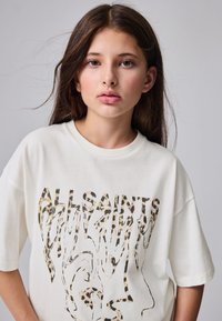 Wit katoenen T-shirt met een grafische print van luipaardpatronen en de tekst "ALLSAINTS" in verschillende lijnstijlen. Korte mouwen en een losse pasvorm.