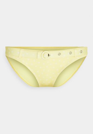 Yellow bikini bottom with white polka dots, textured material, and a belt with a circular buckle and metal hardware accents.