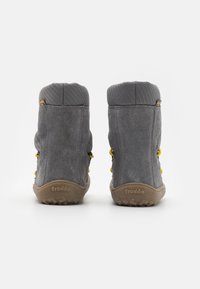 Bottes chevilles en daim gris avec dessus texturé, accents de laçage jaunes, et semelles en caoutchouc avec un motif de crampons. Marque "froddo" sur le talon.